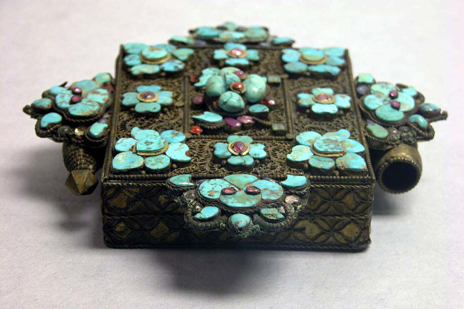 Historic Tibetan amulet case with turquoise-colored inlays in a Metropolitan Museum of Art collection photograph.