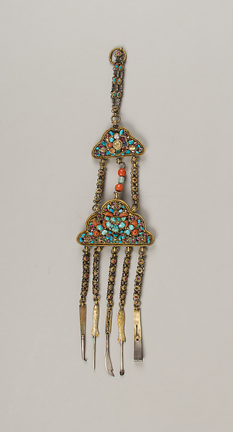 Jeweled historical belt hanging with several small grooming tools suspended below it